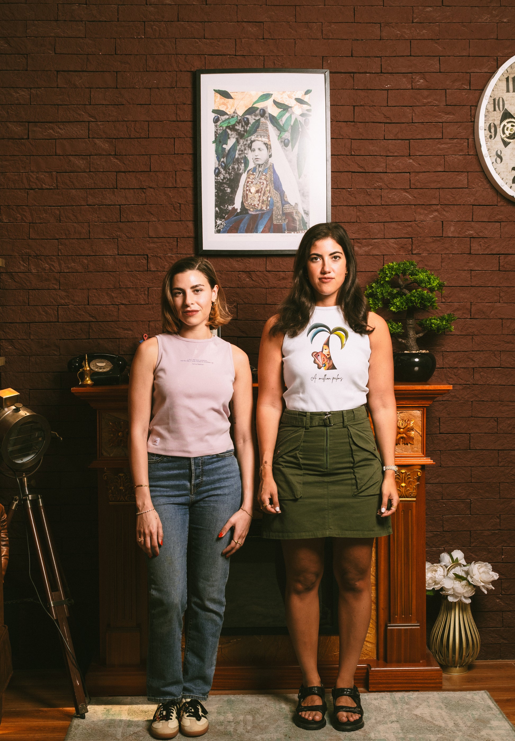 Two models wearing sleeveless art tank tops by Mistica.